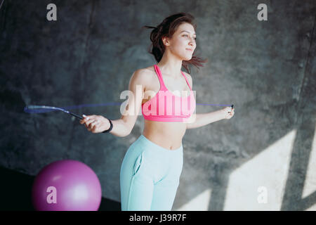 Concept de remise en forme. Mode de vie sain. Jeune femme sautant slim avec la corde à sauter dans la salle de sport Banque D'Images