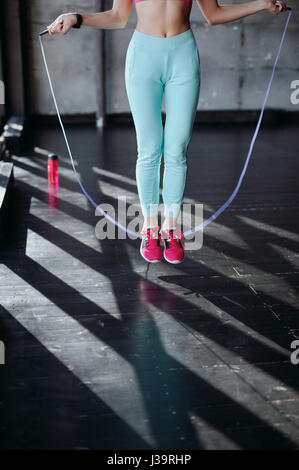 Concept de remise en forme. Mode de vie sain. Jeune femme sautant slim avec la corde à sauter dans la salle de sport Banque D'Images