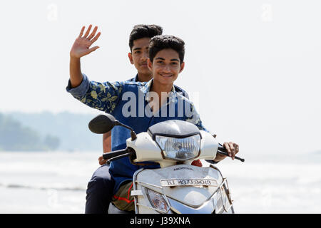 Deux jeunes garçons rouler une moto le long menMuzhappilangad beach, Kerala's drive-in seulement plage, Kannur(Cannanore), Kerala, Inde du Sud, l'Asie du Sud. Banque D'Images