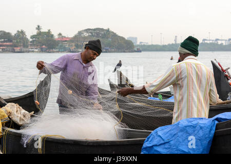 Les pêcheurs Keralan contrôler leurs filets sur la rive à Kochi (Cochin), Kerala, Inde du Sud, en Asie du Sud Banque D'Images