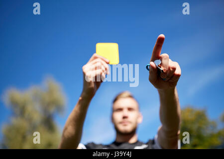 Arbitre sur terrain de football montrant carte jaune Banque D'Images