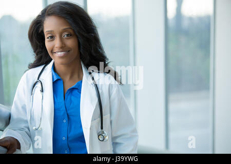Closeup portrait of smiling confident female amical, professionnel de santé avec manteau de laboratoire, stéthoscope, les bras croisés. Hôpital clinique isolé retour Banque D'Images