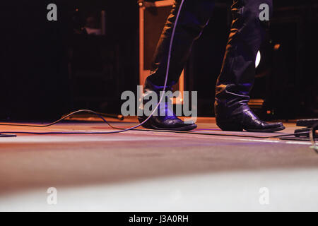 Pieds d'un chanteur à l'occasion d'un concert, détail d'un concert de rock, musique et parti Banque D'Images