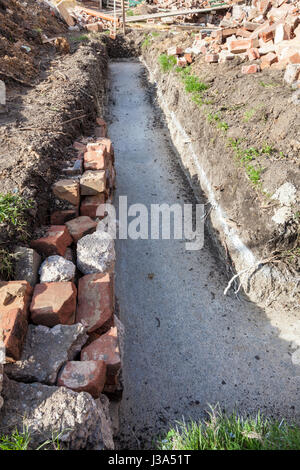 La tranchée de fondation rempli de béton pour une extension de bâtiment sur un chantier de construction. Angleterre, Royaume-Uni Banque D'Images