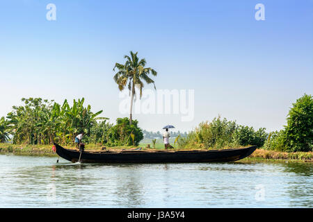 Un homme tenant un parapluie Keralan ressemble à travers les rizières du Kerala backwaters près de Alleppey (Alappuzha), Kerala, Inde du Sud, en Asie du Sud Banque D'Images