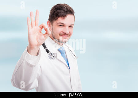 Portrait of medical doctor showing ok sign sur fond bleu avec zone de texte Banque D'Images