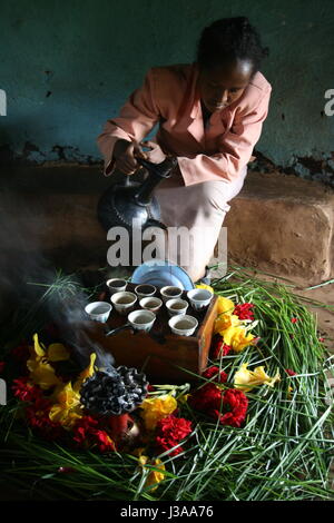 Femme éthiopienne d'effectuer la cérémonie du café traditionnel dans sa maison, dans la région de Kaffa en Éthiopie, où le grain de café. oriiginated Banque D'Images