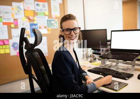 Portrait of businesswoman working on numériseur at desk in office Banque D'Images