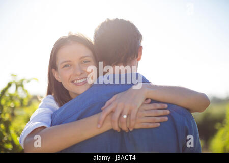 Happy woman hugging son petit ami à la ferme au cours de journée ensoleillée Banque D'Images