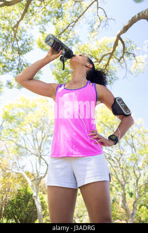 Close-up of female jogger l'eau potable dans le parc Banque D'Images