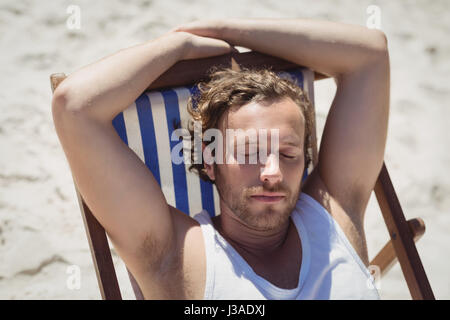 Portrait de jeune femme relaxaing on lounge chair at beach au cours de journée ensoleillée Banque D'Images