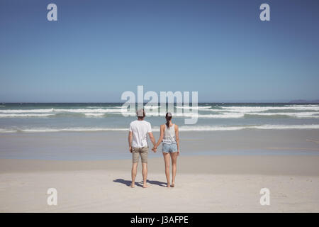 Vue arrière du couple plage en journée ensoleillée Banque D'Images