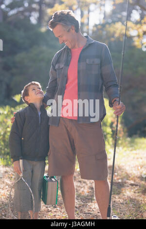 Père et fils à l'un l'autre avec du matériel de pêche aux beaux jours Banque D'Images