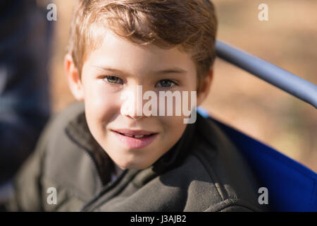 Close up portrait of smiling boy sitting on chair Banque D'Images