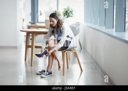 Femme portant des chaussures de toile in office Banque D'Images