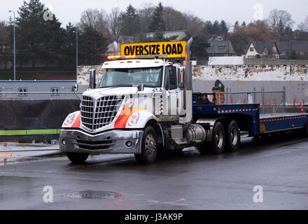 Ergonomique, moderne et élégant, un gros camion camion semi-professionnel à l'aide d'un signe de la cabine et la charge surdimensionnée un mauvais plat semi-remorque Banque D'Images