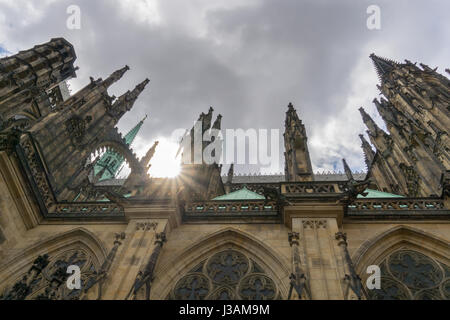 À la recherche jusqu'à l'architecture gothique de la Cathédrale St Vitus à Prague, le soleil les poussées entre les tours. Banque D'Images