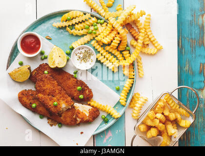 Fish and chips avec des sauces sur la table rustique en bois Voir l'espace vide Banque D'Images