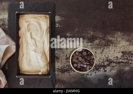 Glace maison avec un bol de chocolat dans une vue supérieure aux tons sombres de l'espace vide de l'image Banque D'Images