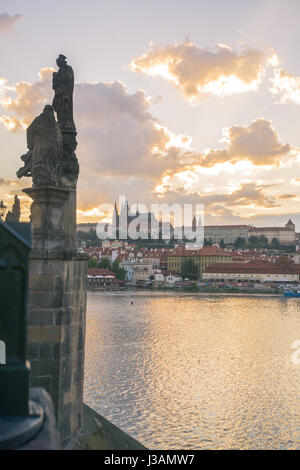 La vue impressionnante sur le château de Prague, du pont Charles au coucher du soleil, avec des statues du Pont Charles en shot. Banque D'Images