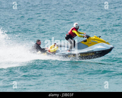 Newquay, Royaume-Uni. 4 mai, 2017. Sauvetage en mer par des sauveteurs. 4th, mai 2017. Un homme et une femme sur les planches sont sauvés de la digue par les rochers à fistral sud par un sauveteur RNLI sur un scooter à la plage de Fistral, Newquay, Cornwall, UK. Robert Taylor/Alamy Live News Banque D'Images