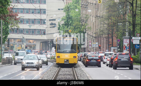 Stuttgart, Allemagne. Le 05 mai, 2017. Voitures de route par un tram exploité par des Tramways de Stuttgart (Stuttgarter Straßenbahnen AG AG, SSB) à Stuttgart, Allemagne, 05 mai 2017. Une taxe sur le transport aérien est actuellement en discussion dans le cadre d'un plan éventuel de maintenir la qualité de l'air. Dit la taxe serait d'encourager les propriétaires à laisser leur voiture à la maison et prendre les bus et trams à la place. Photo : Lino Mirgeler/dpa/Alamy Live News Banque D'Images