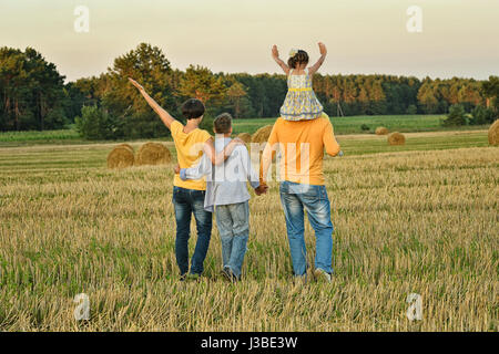 Heureux parents avec enfants au coucher du soleil Banque D'Images