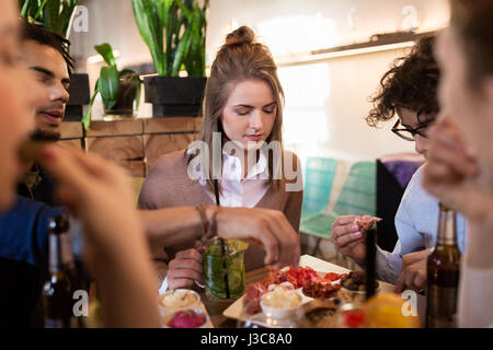 Heureux les amis manger et boire au bar ou au café Banque D'Images