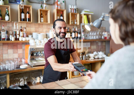 Homme ou serveur avec lecteur de carte et le client au bar Banque D'Images