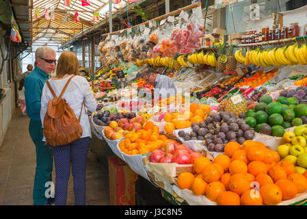 Les gens de décrochage de fruits, vue d'un couple mature discutant de ce qu'il faut acheter à un stand de fruits dans le marché historique Mercado do Bolhao à Porto, Portugal Banque D'Images