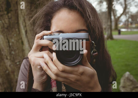 Close-up of woman taking photo de l'appareil photo numérique au park Banque D'Images