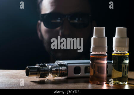 Vaping liquide e isolé et appareil pour cigarette électronique sur un homme barbu portant des lunettes de soleil Banque D'Images