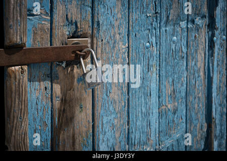 Cadenas sur une vieille porte en bois peint en bleu Banque D'Images