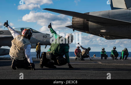 Les marins américains pour signal un USN E/A-18G Growler des avions d'attaque électronique aéroporté à lancer à partir de la cabine de pilotage à bord de la marine américaine de classe Nimitz porte-avions USS Dwight D. Eisenhower, le 9 avril 2017 dans l'océan Atlantique. (Photo de la psc3 Nathan T. Beard/Planetpix via l'US Navy) Banque D'Images