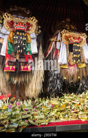 Colorée et deux costumes de Barong richement décoré de la mythologie balinaise, le folklore et la légende avec des tas d'offrandes à leurs pieds à la cérémonie Bali Banque D'Images