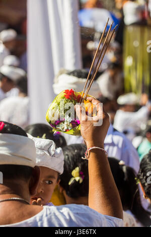 Encens et offrandes religieuses de Canang Sari dans la main tendue d'un homme hindou lors d'une cérémonie religieuse dans un temple hindou à Bali Banque D'Images