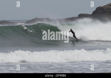 Surfer en essayant d'attraper une vague dans la plage de Zurriola (San Sebastian, Espagne). Banque D'Images