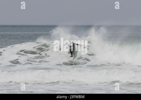 Lonely surfer une vague de coupe en deux à San Sebastian (Guipuzcoa, Espagne) 2017. Banque D'Images