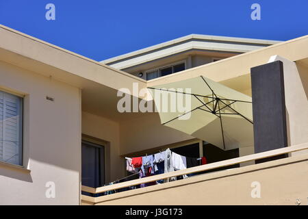 Blanchisserie séchage sur balcon de l'immeuble avec du plâtre bardage. Banque D'Images