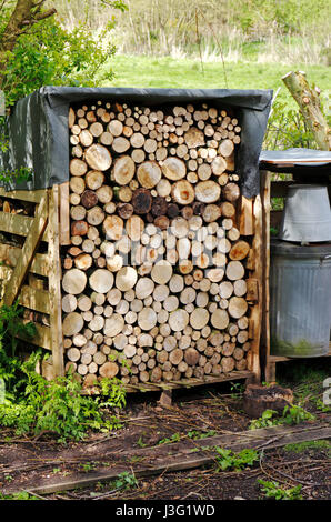 Un magasin de bois rond dans un jardin à l'arrière pays à Norfolk, Angleterre, Royaume-Uni. Banque D'Images