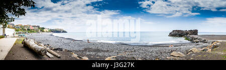 Rocky et plage de sable foncé à Funchal, sur la côte sud de Madère. Banque D'Images