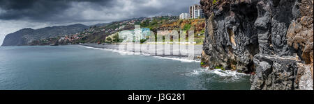 Rocky et plage de sable foncé à Funchal, sur la côte sud de Madère. Banque D'Images