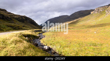 Un rocky mountain stram traverse Glen Shieldaig valley, le long de la route d'un896 Torridon. Banque D'Images