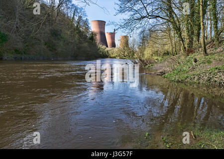 Faible niveau de la vue des tours de refroidissement désaffectée à Buildwas power station, se reflétant dans la rivière Severn. Banque D'Images