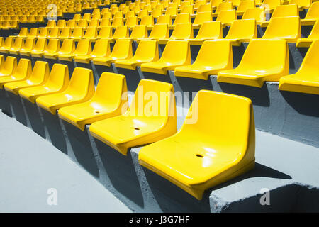 Des chaises en plastique jaune dans une rangée. Abstract background Banque D'Images