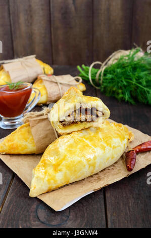 National traditionnel anglais (Cornish) galettes de viande (PIE) - 'Cornish pasty' sur une table en bois sombre. Le déjeuner mineur. Vue verticale. Banque D'Images