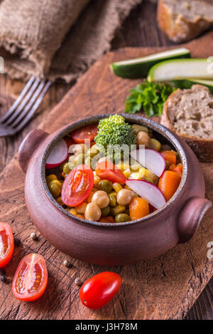 Wegetable dans salade de tomates avec bol accueil conçu sur la table en bois. Banque D'Images