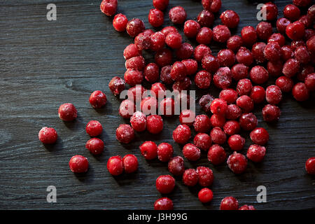 Beaucoup de cerises congelées sans bâtons sur un fond noir en bois.Des vitamines et une alimentation saine Banque D'Images