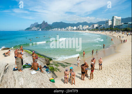 RIO DE JANEIRO - 6 février 2017 : Les Brésiliens se rassemblent sur les rochers à la fin de l'Arpoador Ipanema Beach par un beau matin d'été. Banque D'Images