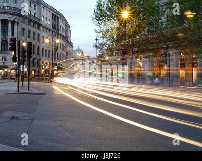 Des sentiers de lumière provenant des voitures et des bus de nuit à partir de la bande à Trafalgar Square, Londres, UK Banque D'Images